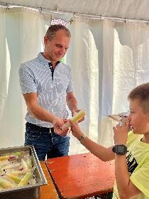 Bürgermeister Fran Buß gibt im Feriencamp einem Kind ein Eis