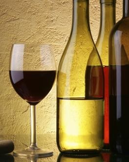 Weinglas mit drei Weinflaschen