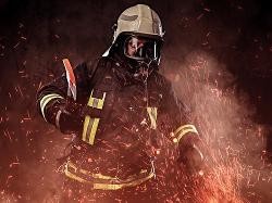 Ein Feuerwehrmann in Uniform und mit Sauerstoffmaske hält eine rote Axt. Um ihn herum sprühen Funken im Rauch.