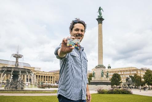 Mann steht auf dem Stuttgarter Schloßplatz und hält die ErlebnisCard in der Hand