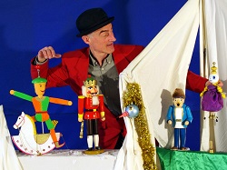 Schauspieler mit großen Erzgebirge-Figuren stellt Szene aus Stück nach.